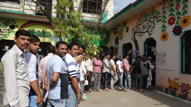Voters outside a polling booth in Meerut in Uttar Pradesh on Thursday.(HT PHOTO)