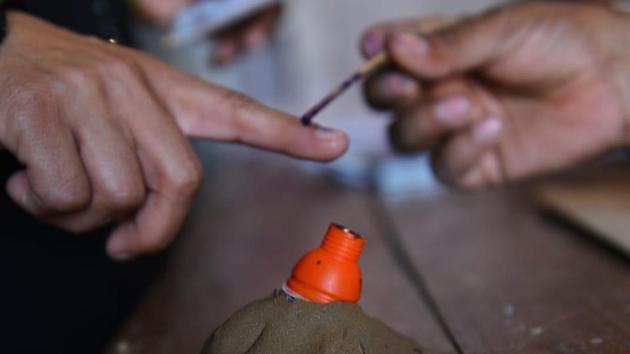 An election officer applies indelible ink on the finger of a voter.(Vipin Kumar/HT photo) An election officer applies indelible ink on the finger of a voter.(Vipin Kumar/HT photo)
