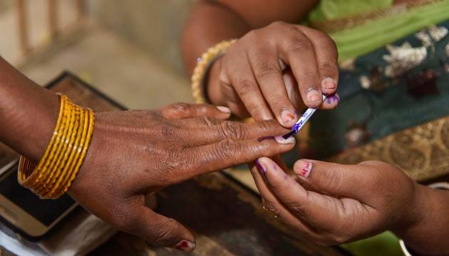 An election officer puts an indelible ink mark on the finger of a voter on Thursday, April 11.(PTI)