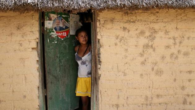 Sideneia Francisco de Lima, 15, an indigenous Macuxi girl, looks out of her house at the community of Tamandua. In Raposa Serra do Sol, Daniel Andrade butchered a cow’s carcass and held up a cut of fresh beef. Nobody goes hungry on the reservation, he countered. (Bruno Kelly / REUTERS)