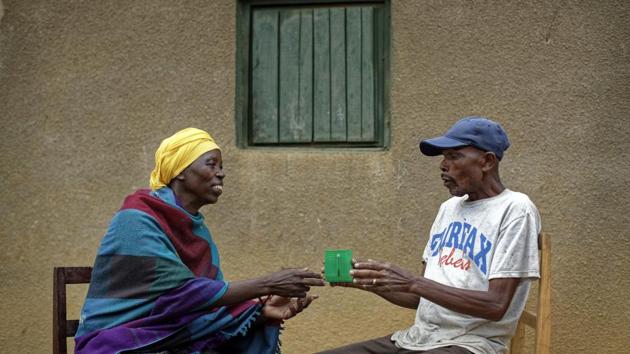 Genocide survivor Laurencia Mukalemera (L), a Tutsi, is offered a cup of water by Tasian Nkundiye (R), a Hutu who murdered her husband and spent eight years in prison for the killing and other crimes, before being interviewed at Nkundiye’s home in the reconciliation village of Mbyo, near Nyamata, in Rwanda. (Ben Curtis / AP) 