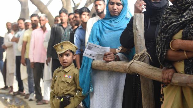 A bit of a ways to go until this young boy could be on the other side of the barricade where voters are queued outside a polling station, but this costumed police officer no doubt made an impression, at Sawal village, in Uttar Pardesh. (Raj K Raj / HT Photo)