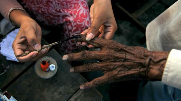 A polling officer puts an indelible ink mark on the index finger of a voter, in Jammu. In Baramulla in the Kashmir valley and the Jammu region, voter turnout was 32.29% and 67.39%. (Nitin Kanotra / HT Photo)