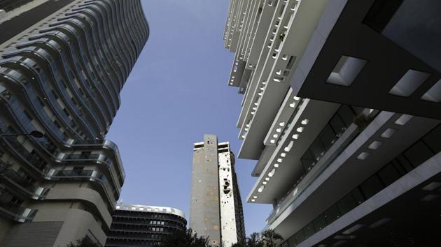 Beirut’s landmark Holiday Inn hotel (C), a hulking, bullet-riddled blue and white building riddled with bullets and shells, stands between new designer towers. The hotel, which opened just two years before the war broke out on April 13, 1975, was destroyed early on and used as a sniper’s nest. It has stood deserted since then, its shareholders locked in legal dispute. (Hassan Ammar / AP)