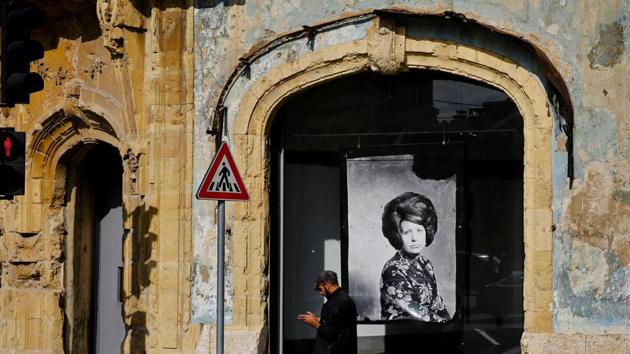 A man passes in front of Beit Beirut, the nearly 100 year-old house that served as a sniper position. “You’re walking around going about your daily business when suddenly you come face to face with a scene that takes you back to the old days,” Mandour said. (Hassan Ammar / AP)