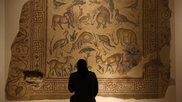 A visitor checks the mosaic of the Good Shepherd that was badly damaged in the lower left corner by a sniper during the civil war. The woman keeps plants on the veranda and on the stairs to compensate for the building’s grim facade. “If I had somewhere else to go, I would,” she said, identifying herself by her nickname, Imm Lebnen, or mother of Lebanon. (Hassan Ammar / AP)