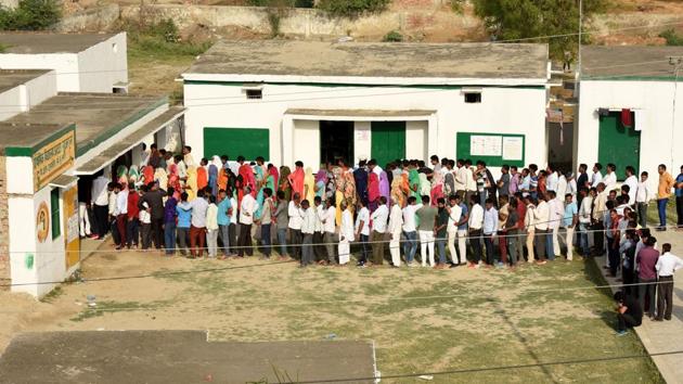People stand in queues outside a station, at Atta Gujjran in Greater Noida. Andhra Pradesh recorded a turnout of 73% and neighbouring Telangana 60%. Turnout was 69%, 60% and 78% , respectively, in Sikkim, Mizoram and Nagaland, in which the elections were concluded in one phase. (Virendra Singh Gosain / HT Photo)