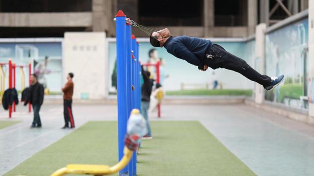 Sun Rongchun, 57, exercises with an improvised cervical traction device attached to a high bar at a sports complex in Shenyang, Liaoning province, China. (Sheng Li / REUTERS) 