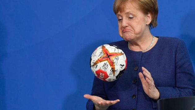 German Chancellor Angela Merkel plays with a handball given to her by the German Handball Federations president (not in picture) as she received the German national handball team at the Chancellery in Berlin, Germany. (John MacDougall / AFP) 