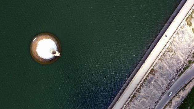 An aerial view from a drone shows water from the artificial Qaraaoun lake running into the overflow pipe near the dam in the west of Lebanon’s Bekaa Valley. The abundance of rain this year led to an overflow drainage in one of the biggest dams in Lebanon. (Joseph Eid / AFP) 