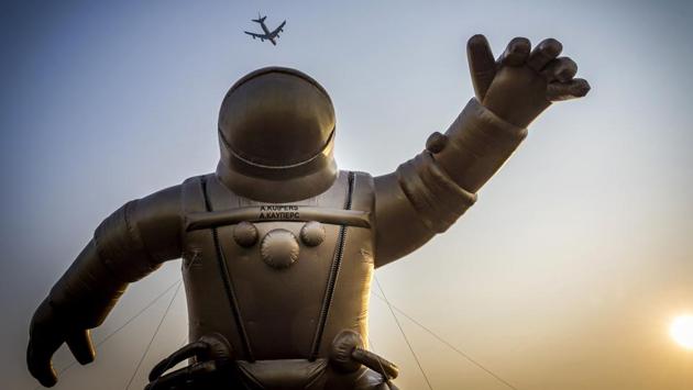 A airliner flies high above a giant gold-colored inflatable astronaut representing Dutch astronaut Andre Kuiper in his astronaut gear to mark the start of the fifth National Museum Week in Sassenheim, Netherlands. (Lex van Lieshout / ANP / AFP) 