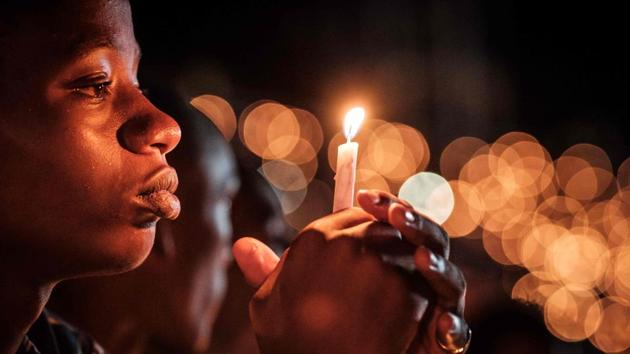 A person holds a candle during a night vigil and prayer at the Amahoro Stadium as part of the 25th Commemoration of the 1994 Genocide, in Kigali, Rwanda. (Yasuyoshi Chiba / AFP) 