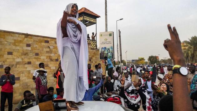 Alaa Salah, a Sudanese woman propelled to internet fame earlier this week after clips went viral of her leading powerful protest chants against President Omar al-Bashir, addresses protesters during a demonstration in front of the military headquarters in the capital Khartoum, Sudan. (AFP) 