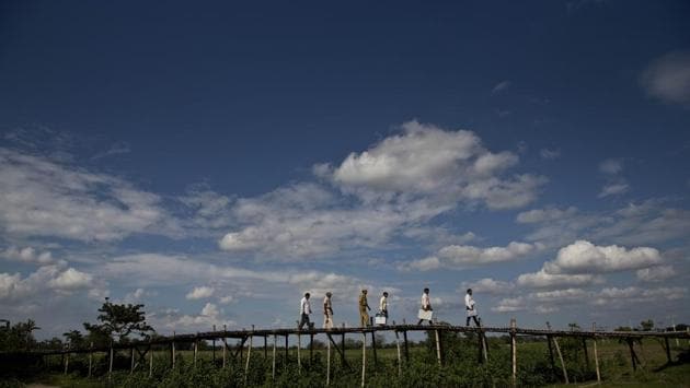 Election officials carry polling material over a bamboo footbridge in Majuli, Assam. (Anupan Nath / AP) Election officials carry polling material over a bamboo footbridge in Majuli, Assam. (Anupan Nath / AP)