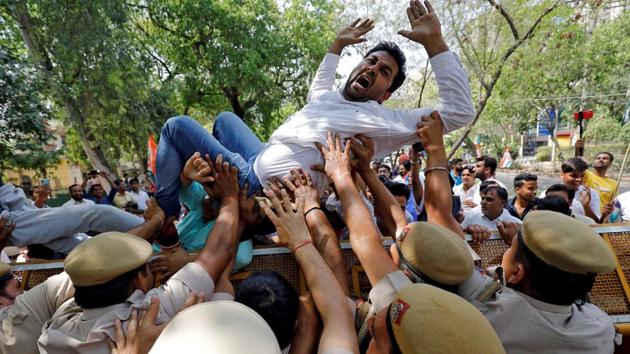 An activist of Delhi Pradesh Youth Congress shouts slogans as police try to stop him cross a barricade during a protest against what the activists say are politically motivated raids by Income Tax officials, in New Delhi. (Anushree Fadnavis / REUTERS) An activist of Delhi Pradesh Youth Congress shouts slogans as police try to stop him cross a barricade during a protest against what the activists say are politically motivated raids by Income Tax officials, in New Delhi. (Anushree Fadnavis / REUTERS)