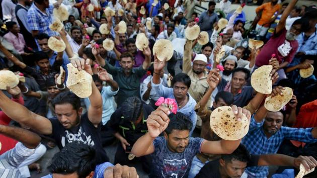 Vendors hold roses and ‘chapatis’ during a protest, after they were disallowed from sitting along roadsides, in Ahmedabad, Gujarat. (PTI) Vendors hold roses and ‘chapatis’ during a protest, after they were disallowed from sitting along roadsides, in Ahmedabad, Gujarat. (PTI)