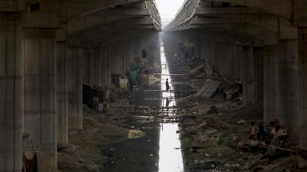A resident walks across a makeshift bridge over a sewage canal under the Digha Bridge link road in Danapur, Bihar. (Xavier Galiana / AFP) A resident walks across a makeshift bridge over a sewage canal under the Digha Bridge link road in Danapur, Bihar. (Xavier Galiana / AFP)