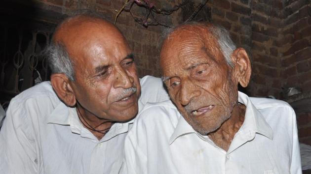 Former village head Ram Prasad Sharma (right) with his son Satish Sharma at his house in Semra village(Raju Tomar/ht photo)