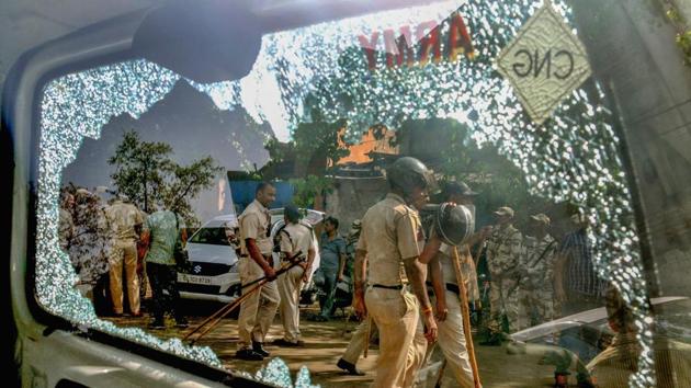 New Delhi: Police personnel are seen through a broken car window following clashes between locals and the police during a sealing drive in Mayapuri, New Delhi, Saturday, April 13, 2019. (PTI Photo) (PTI4_13_2019_000145B)(PTI) New Delhi: Police personnel are seen through a broken car window following clashes between locals and the police during a sealing drive in Mayapuri, New Delhi, Saturday, April 13, 2019. (PTI Photo) (PTI4_13_2019_000145B)(PTI)