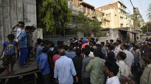 New Delhi, India - April 13, 2019: People gather outside a sealed shop following an order from Monitoring Committee at Mayapuri industrial area in New Delhi, India, on Saturday, April 13, 2019. As many as nine policemen and four paramilitary personnel were injured in the incident. (Photo by Biplov Bhuyan/ Hindustan Times) (Biplov Bhuyan/HT PHOTO) New Delhi, India - April 13, 2019: People gather outside a sealed shop following an order from Monitoring Committee at Mayapuri industrial area in New Delhi, India, on Saturday, April 13, 2019. As many as nine policemen and four paramilitary personnel were injured in the incident. (Photo by Biplov Bhuyan/ Hindustan Times) (Biplov Bhuyan/HT PHOTO)
