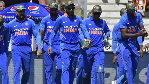India's captain Virat Kohli (C) and his teammates wearing army camouflage-style caps walk onto the field.(REUTERS)