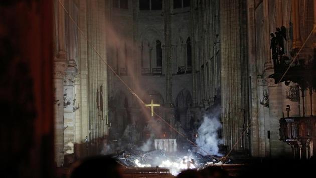 Smoke rises around the altar in front of the cross inside the Notre Dame Cathedral. The building survived the devastation of two global conflicts in the 20th century and famously rang its bells on August 24, 1944, the day of the Liberation of Paris from German occupation at the end of the World War II. (Philippe Wojazer / Pool / REUTERS) Smoke rises around the altar in front of the cross inside the Notre Dame Cathedral. The building survived the devastation of two global conflicts in the 20th century and famously rang its bells on August 24, 1944, the day of the Liberation of Paris from German occupation at the end of the World War II. (Philippe Wojazer / Pool / REUTERS)