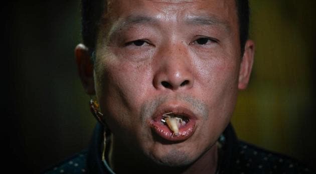 Cockroach farmer Li Bingcai eating an exuvial roach at his farm in Yibin, China's southwestern Sichuan province.(AFP)