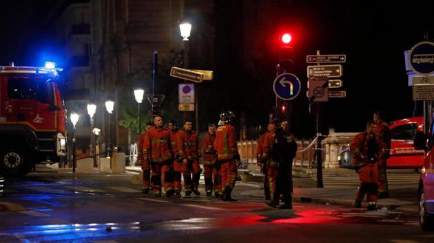 Firefighters gather near a fire truck as they work to contain a fire at Notre-Dame Cathedral in Paris early on April 16, 2019. - The main structure of Notre-Dame cathedral in central Paris has been saved after hours of fire-fighting to put out a devastating blaze, the city's top fire official said late on April 15. (Photo by Zakaria ABDELKAFI / AFP)(AFP)