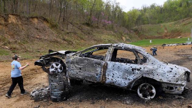 A boy walks past a destroyed car on the main firing line. Hearing and eye protection is strongly recommended. (Andrew Caballero-Reynolds / AFP)