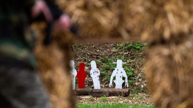 A woman runs to get into a shooting position in a sub-machine gun shooting competition. It has evolved into the biggest private machine gun shoot in the world, attracting thousands of automatic weapons enthusiasts from around the United States and abroad. (Andrew Caballero-Reynolds / AFP)