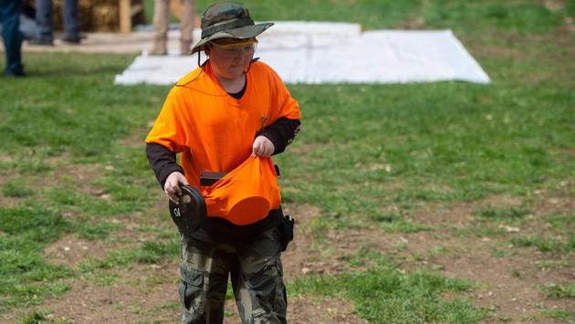 A young volunteer carries empty ammunition cartridges after a shooter ran through a sub-machine gun competition. Machine gun owners can reserve spots on the main firing line, but there is a waiting list of up to 10 years. (Andrew Caballero-Reynolds / AFP)