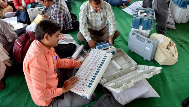 Uttar Pradesh, April 17 (ANI): Polling officials checking Electronic Voting Machine (EVM) at distribution center before leaving Second Phase of Lok Sabha election, in Mathura on Wednesday. (ANI Photo)