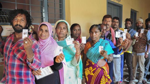 Bengaluru: Voters show their ID cards as they wait in a queue to cast vote at a polling station, during the 2nd phase of Lok Sabha elections in Bengaluru, Thursday, April 18, 2019. (PTI Photo/Shailendra Bhojak)(PTI4_18_2019_000121B)(PTI)