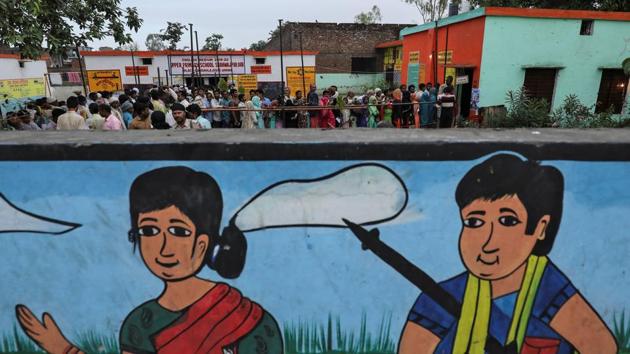 Voters stand outside a polling station in Amroha, Uttar Pradesh. Due to lack of development in Hathras voters in Garhi herbal village of Sadabad boycotted the election. At Birjapur polling station in Mathura people complained that they are not allowed to vote despite having Aadhar card as identity proof. (Anushree Fadnavis / REUTERS)