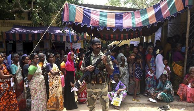 A soldier stands guard as Indians wait in a queue to cast their votes during the second phase of general elections in Chennai, India, Thursday, April 18, 2019.(AP)