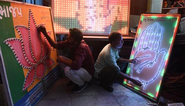 Indian men check electrical lighting signboard of Indian Congress Party (R) and Bhartiya Janta Party (BJP) at a workshop in Ahmedabad on April 3, 2019. (AFP file photo) Indian men check electrical lighting signboard of Indian Congress Party (R) and Bhartiya Janta Party (BJP) at a workshop in Ahmedabad on April 3, 2019. (AFP file photo)