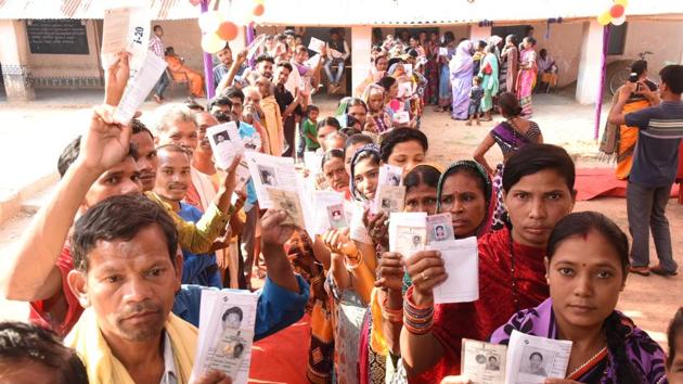 Voters show their identity cards as they stand in queues to cast their votes during the second phase of the general elections at a polling station, in Kandhamal district, Odisha, April 18, 2019.(Arabinda Mahapatra / HT Photo)