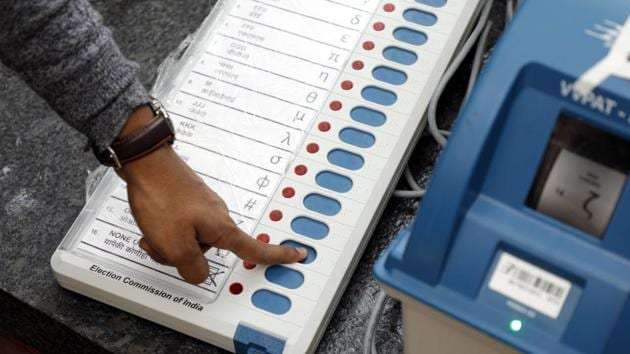 An election commission official checks an EVM.(Rahul Raut/HT Photo)