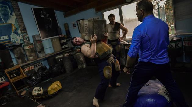 Inigo Eizagirre, 24, holds a 100 kilograms stone during a training session in the basque village of Zarautz. Eizagirre can raise a rectangular stone weighing 100 kilograms up to 21 times in less than three minutes, a pace that gives him a chance to win a tournament. (Alvaro Barrientos / AP) Inigo Eizagirre, 24, holds a 100 kilograms stone during a training session in the basque village of Zarautz. Eizagirre can raise a rectangular stone weighing 100 kilograms up to 21 times in less than three minutes, a pace that gives him a chance to win a tournament. (Alvaro Barrientos / AP)