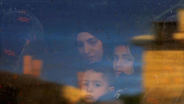 The wife and children of Palestinian prisoner Ayman Ghareeb, who is held in an Israeli jail, look out of a bus window on their way to visit him in the jail, as Palestinians mark Prisoners’ Day, in Tubas in the Israeli-occupied West Bank. (Raneen Sawafta / REUTERS) 
