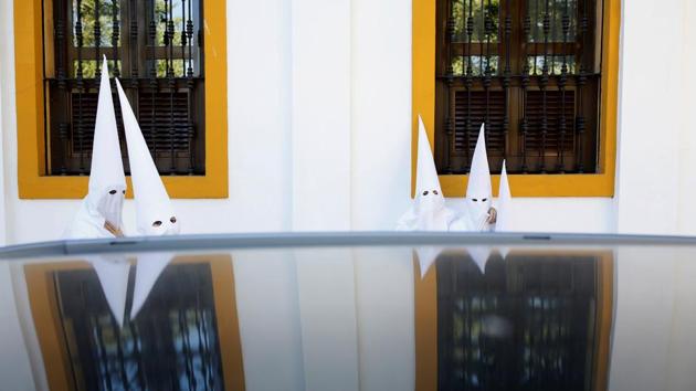 Penitents of La Paz (The Peace) brotherhood make their way to a church before taking part in a procession during Holy Week in the Andalusian capital of Seville, southern Spain. (Marcelo del Pozo / REUTERS) 