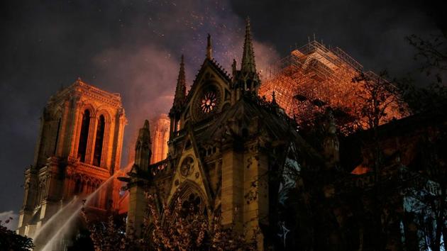 Sparks fill the air as Paris Fire brigade members spray water to extinguish flames as the Notre Dame Cathedral burns in Paris, France. (Philippe Wojazer / REUTERS) 