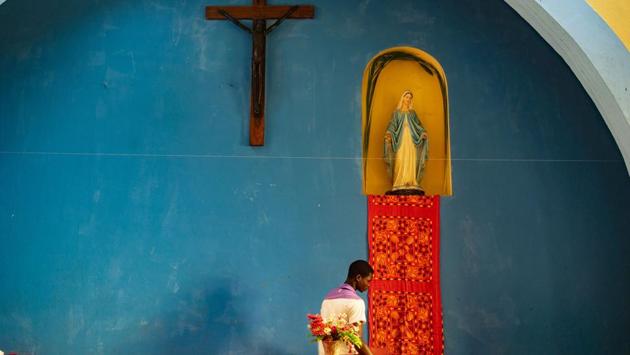 A boy prepares the church ahead of a palm Sunday mass at Lady of Grace Parish Catholic Church in Barrio Manasse, Buzi District, Sofala Province, Mozambique. (Zinyange Auntony / AFP) 
