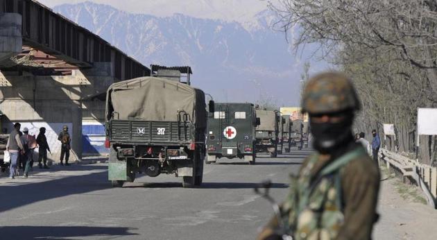 An army personnel stands guard as an army convoy crosses the national highway on the outskirts of Srinagar on April 7, 2019 when the government banned civilian traffic on Srinagar-Jammu national highway for two days in a week (Sunday and Wednesday) for safe passage of security force convoys. (HT PHOTO) An army personnel stands guard as an army convoy crosses the national highway on the outskirts of Srinagar on April 7, 2019 when the government banned civilian traffic on Srinagar-Jammu national highway for two days in a week (Sunday and Wednesday) for safe passage of security force convoys. (HT PHOTO)