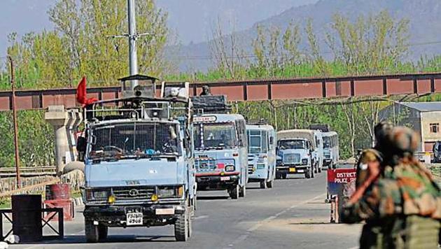 Soldiers stand guard as CRPF convoy crosses the national highway on the outskirts of Srinagar.(HT Photo) Soldiers stand guard as CRPF convoy crosses the national highway on the outskirts of Srinagar.(HT Photo)
