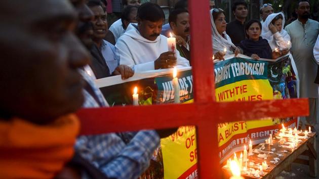 Pakistani members of civil society hold candles to pay tribute to the Sri Lankan blasts victims during a vigil in Lahore.(AFP)