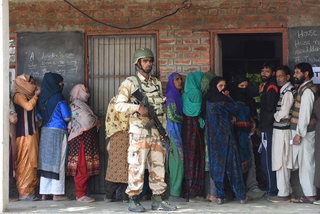 Paramilitary soldier stands guard as voters wait in a queue to cast their votes outside a polling station during the third phase of general election in Shangus, South Kashmir. The overall poll percentage in Anantnag at 11.00 am was 4.79%, an official spokesman said. Mobile Internet facility and train services have been suspended for the day. (Waseem Andrabi / HT Photo) Paramilitary soldier stands guard as voters wait in a queue to cast their votes outside a polling station during the third phase of general election in Shangus, South Kashmir. The overall poll percentage in Anantnag at 11.00 am was 4.79%, an official spokesman said. Mobile Internet facility and train services have been suspended for the day. (Waseem Andrabi / HT Photo)