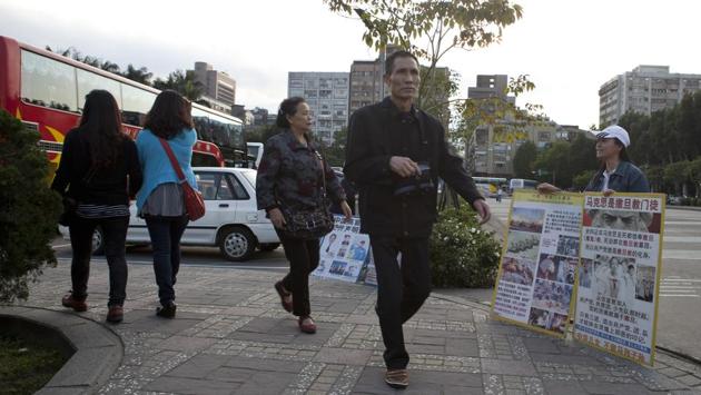 Falun Gong memebers show Chinese tourist documents and photos of Chinese persecution on April 15, 2013 in Taipei, Taiwan. The movement has also adopted a more political stance in some parts of the world. In Hong Kong, where Falungong activists hand out flyers and try to talk to people -- especially mainland tourists -- it has taken on a stridently anti-communist tone. (Ashley Pon / Getty Images)