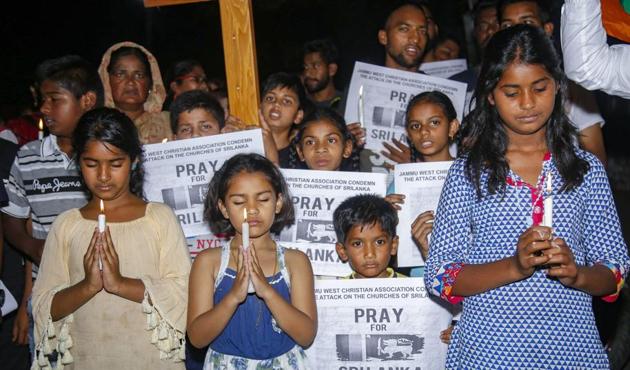 Members of the christian community hold candles to pay tribute to the victims of Sri Lanka terror attacks, in Jammu, on Monday. As the news of the blasts flashed across the country, Sri Lankan students in Pune cancelled Easter programmes.(HT PHOTO)