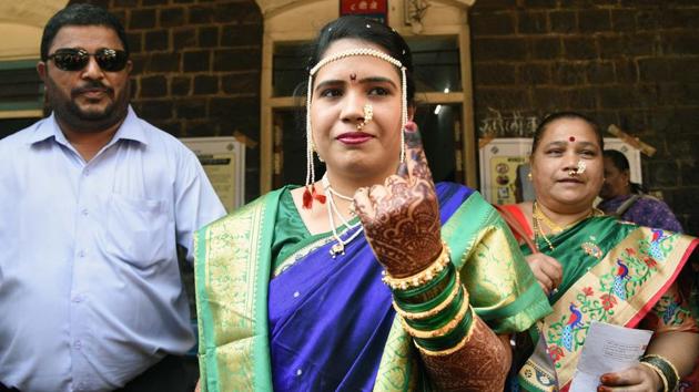 Shraddha Bhagat (C) poses for photo outside polling booth on election day at Nutan Marathi Vidyalay, Appa Balwant Chowk. Shraddha casted her vote just before her wedding ceremony which was held in Bhugaon.  (Pratham Gokhale/HT Photo) 